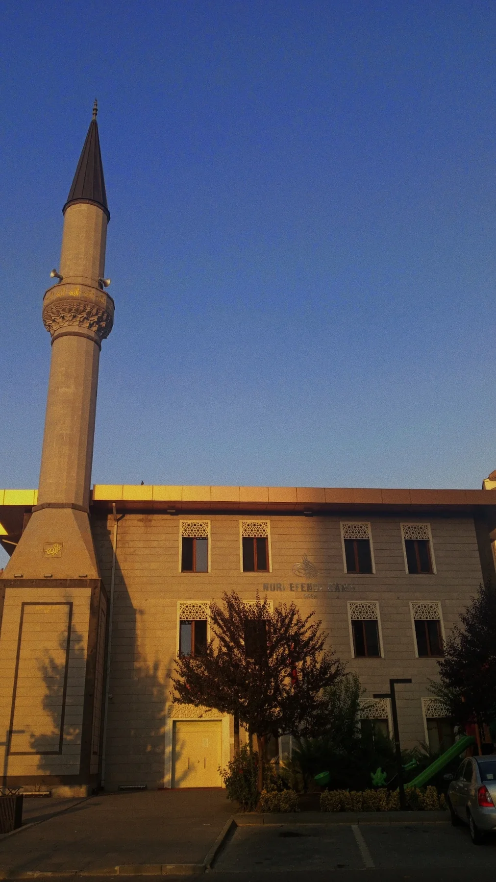 Akşam güneşi, taş cephe ve minare.