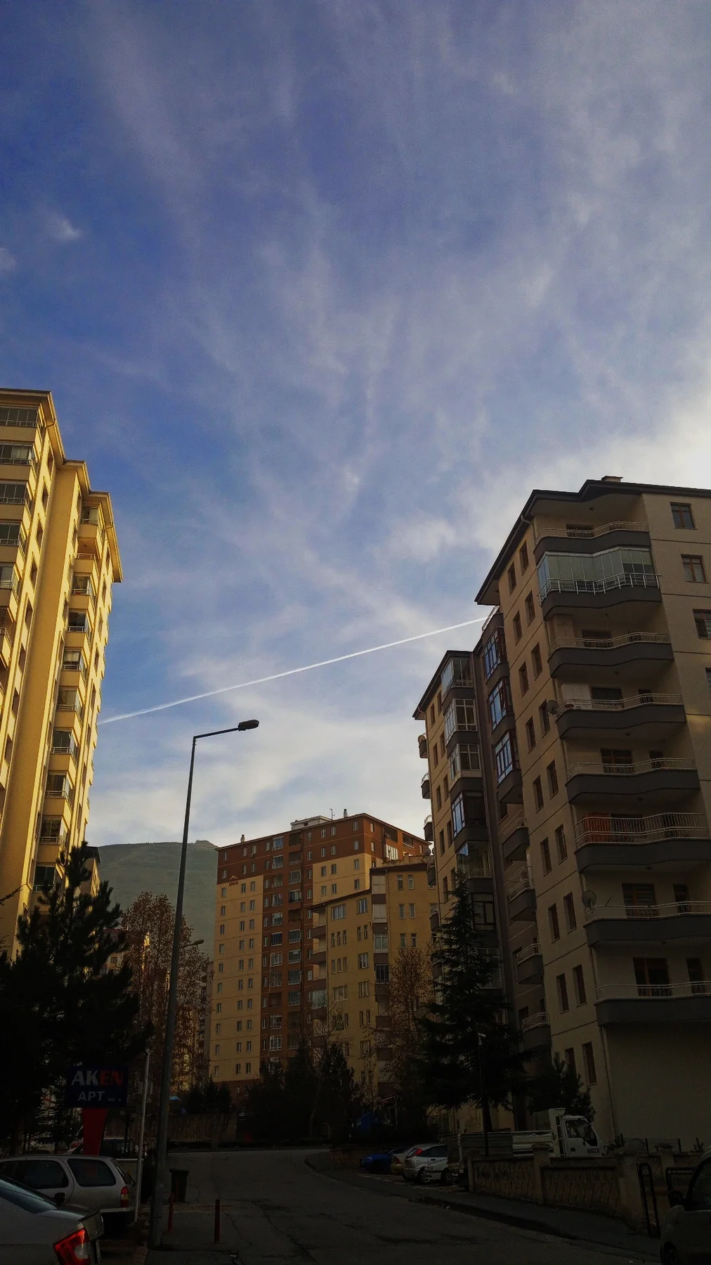 Apartmanların arasında bir uçak izi.