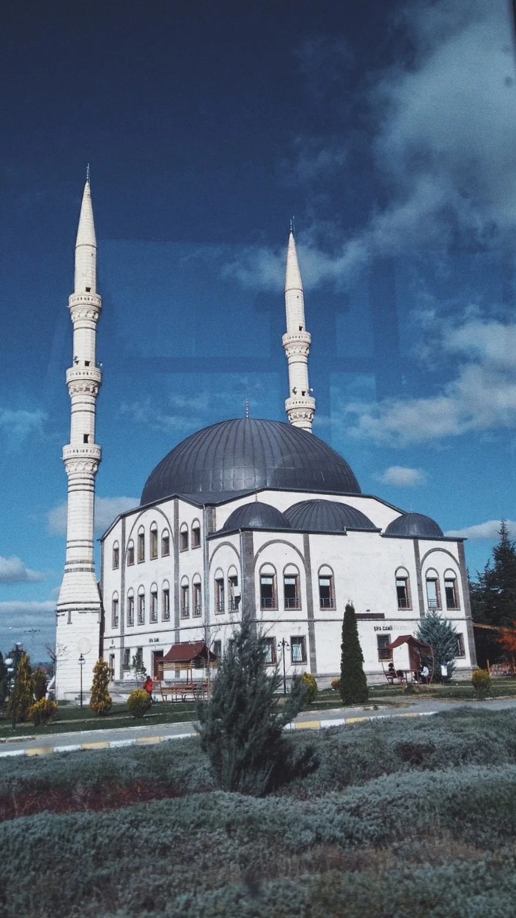 Bulutların altında beyaz bir cami.