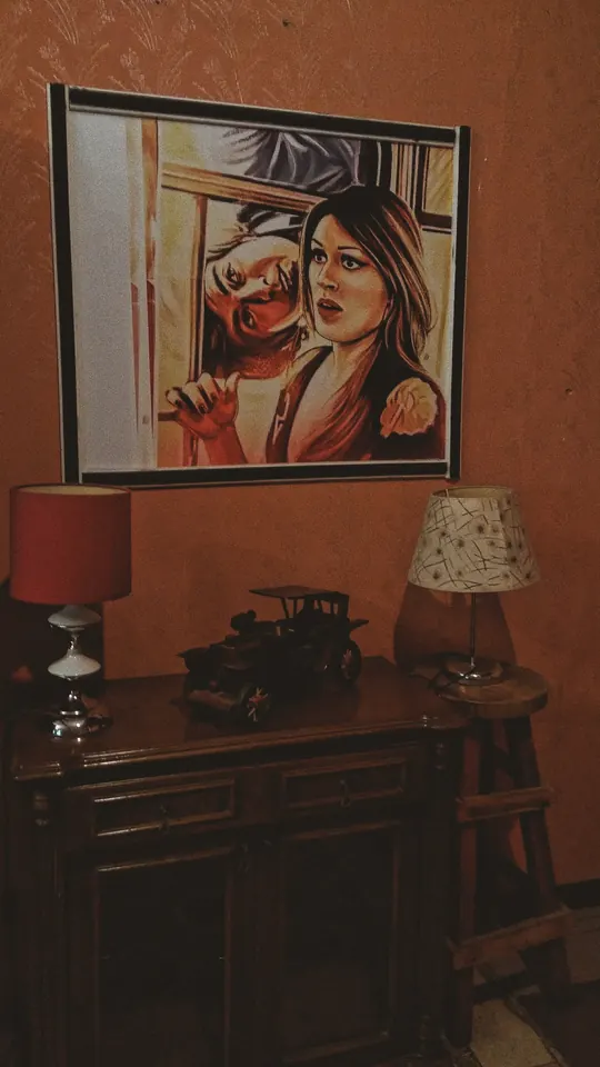 Duvarda bir tablo, altında eski lambalar.