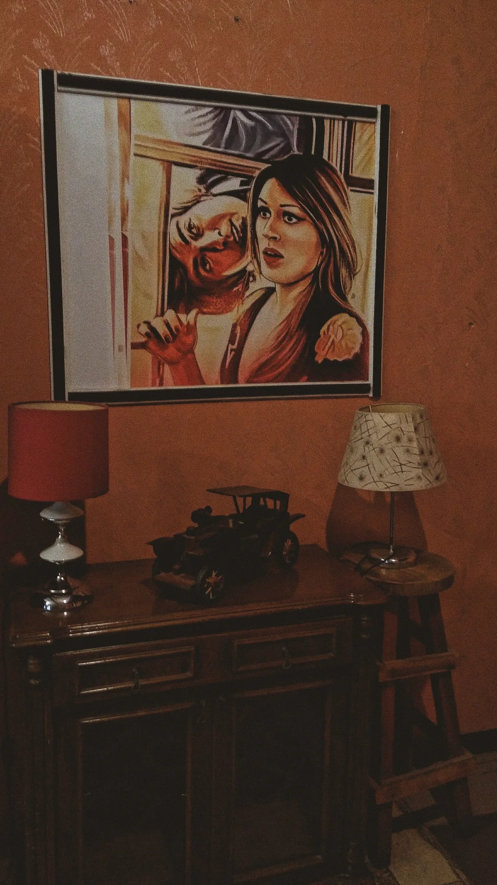 Duvarda bir tablo, altında eski lambalar.