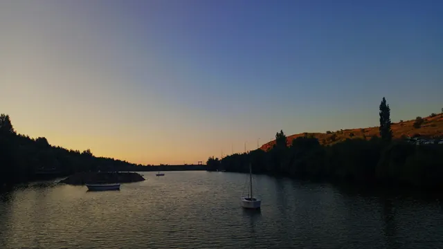 Koyda gün batımı, demirli tekneler.