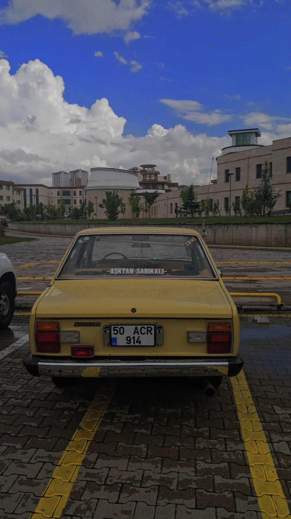 Park yerinde sarı bir Tofaş. Bazı arabalar eskimiyor, klasikleşiyor.